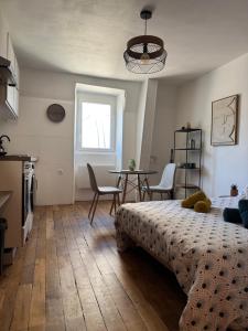 ブールジュにあるCharmant Appartement au Coeur de Bourges 24のベッドとテーブルと椅子のある寝室 +11枚の写真