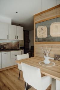 a kitchen with a wooden table and white cabinets at SAM`s hairBERGE Apartments in Lofer