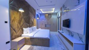 a hotel room with a bed and a tv at Brown condo in Lekki