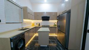 a kitchen with a washer and a sink and a refrigerator at Brown condo in Lekki
