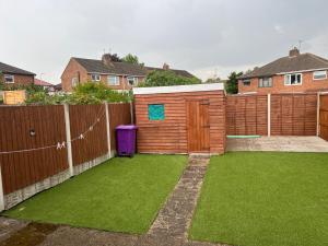 einen Hinterhof mit einem Zaun und grünem Gras in der Unterkunft Five Oaks House- Entire 3 Bedroom House for Family & Contractors with up to 5 sleep- NO PARTIES ALLOWED in Willenhall