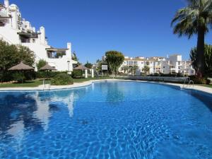 a large blue swimming pool in front of some buildings at Apartamento Calahonda in Mijas Costa