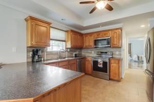 a kitchen with wooden cabinets and a ceiling fan at Long Beach Maple House in Long Beach
