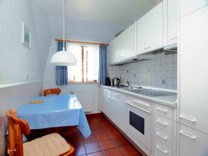 a kitchen with a blue table and a sink at Gaestehaus-Bruhn-3 in Alkersum