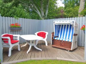 a deck with two chairs and a table and a table and chairs at Gaestehaus-Bruhn-3 in Alkersum +1 photo