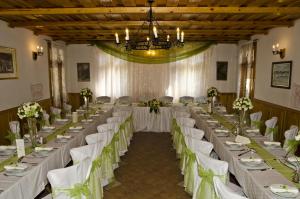 a banquet hall with long tables and white chairs at Rácz Fogadó in Kisoroszi