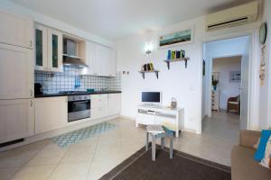 a kitchen with white cabinets and a table and chairs at Il Nido di Montiano, giardino, natura e relax in Magliano in Toscana