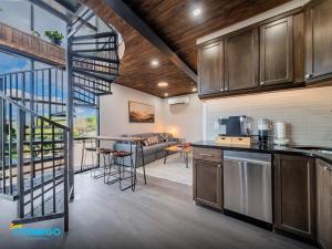 a kitchen with a spiral staircase leading to a living room at Kanab Cube Shipping Cube Rental Experience in Kanab