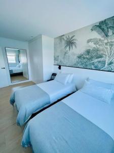 ムシアにあるApartamento Malecón 47のベッドが2つと鏡があるホテルの部屋