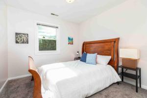 a white bedroom with a bed and a window at Lagoon Basecamp in Farmington