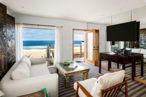 sala de estar con sofá blanco y piano en New The Triton Manhattan Beachfront Escape, en Manhattan Beach