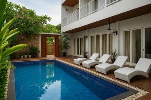 una piscina con sillas blancas junto a una casa en Lumiere Hotel Gili Trawangan, en Gili Trawangan 30 fotos más