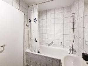 a white bathroom with a tub and a sink at Charmante 1-Zimmer Wohnung in Jena Winzerla in Jena