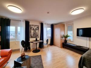 a living room with a couch and a table at Charmante 1-Zimmer Wohnung in Jena Winzerla in Jena