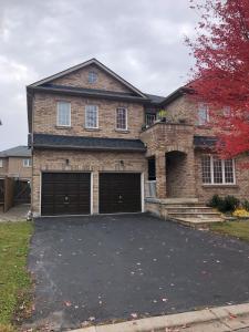 a brick house with two garage doors in a driveway at 2 Bed-2Bath-Kitchen Private Family Couple Work in Newmarket