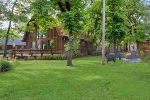 una casa con un patio con un banco y una bandera en Barrel Cabin at Sandy Bass Bay, en Eufaula