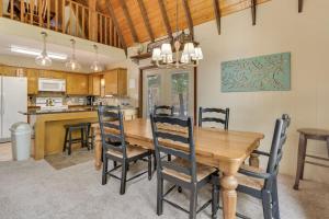 Una cocina y un comedor con mesa y sillas de madera. en Barrel Cabin at Sandy Bass Bay, en Eufaula