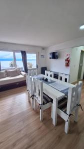 Un comedor blanco con una mesa y sillas blancas. en Los Dones Departamentos DAT, en San Carlos de Bariloche