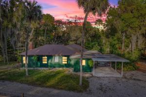 una casa verde con una carpa en el patio en 1920s Speakeasy, Horses Hot Tub 5mi to Beach, en Vero Beach