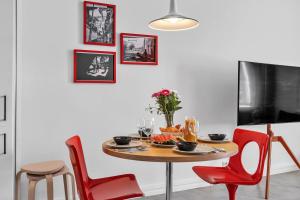 a dining room with a table and red chairs at Red Bauhaus Kamppi Square 35m tram bus Wi-Fi in Helsinki +14 photos