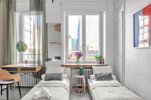 a room with two beds and a table and windows at Red Bauhaus Kamppi Square 35m tram bus Wi-Fi in Helsinki