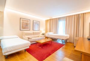 ein Wohnzimmer mit weißen Möbeln und einem roten Teppich in der Unterkunft Aparto-Hotel Rosales in Madrid + 79 Fotos
