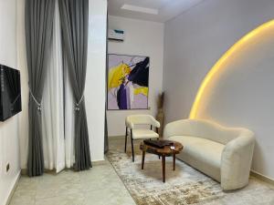 a living room with a couch and a chair and a table at Cabana in Lekki