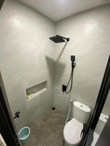 a bathroom with a toilet with a spotlight on the wall at Cleya House Banyuwangi in Giri +15 photos