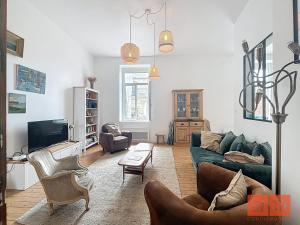 een woonkamer met een groene bank en een tv bij La parenthèse in Wimereux