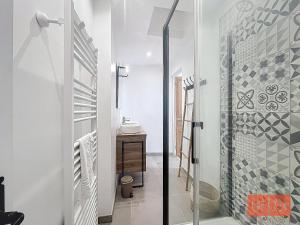 een badkamer met douche en glazen deur bij La parenthèse in Wimereux