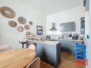 een keuken met een houten tafel en een eetkamer bij La parenthèse in Wimereux +6 foto's