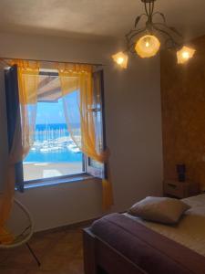 a bedroom with a window with a view of the ocean at Baia Marina Suite with private jacuzzi in Balestrate