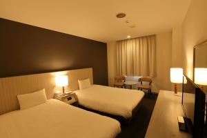 Postel nebo postele na pokoji v ubytování Chisun Hotel Kamata