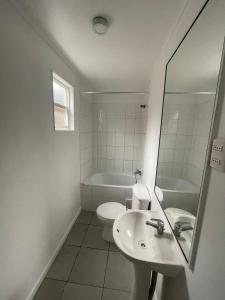 une salle de bain avec un lavabo, des toilettes et un miroir dans l'établissement Arriendo diario, à Valdivia