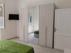 コッレサルヴェッティにあるVillettina con Bagni esclusiviのベッドルーム(鏡、ベッド、テレビ付)