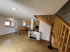 a living room with a staircase and a kitchen at Mountain Chalet in Strembo