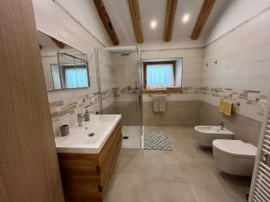 a bathroom with two sinks and a shower and a toilet at Mountain Chalet in Strembo