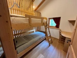 a bedroom with two bunk beds and a desk at Mountain Chalet in Strembo