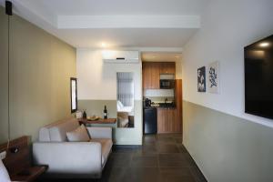 a living room with a couch and a kitchen at Domus Carmel Hotel in Haifa