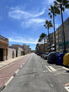 eine leere Straße mit parkenden Autos und Palmen in der Unterkunft Playa Nules beautiful apartment in Mascarell + 7 Fotos