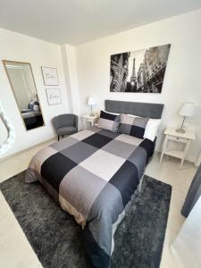 ein Schlafzimmer mit einem großen Bett mit einer schwarzen und weißen Bettdecke in der Unterkunft Playa Nules beautiful apartment in Mascarell