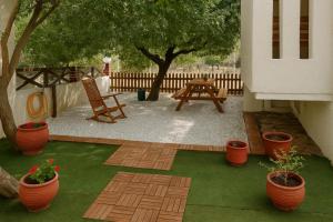 a patio with a picnic table and potted plants at Nicolas Beach in Palaiochora