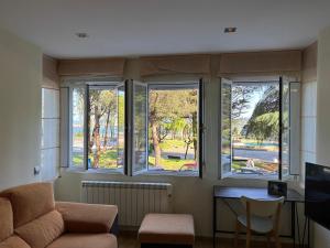 Sala de estar con 3 ventanas y sofá en Apartamento céntrico O Castelo, en Pobra do Caramiñal