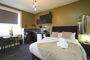 a bedroom with a large bed and a kitchen at Hayy Studio Quiet Comfy Connected in Huddersfield