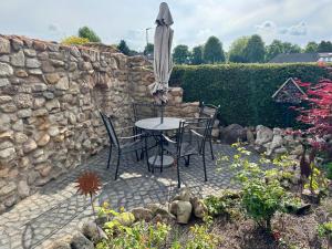 a patio with a table and chairs and an umbrella at Monteurs- und Ferienwohnung Kahmen in Ahaus
