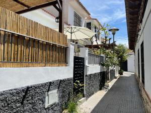 an alley with a fence and an umbrella at Casa Pedregalejo in Málaga