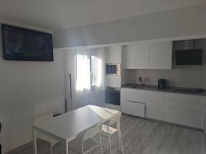 a kitchen with white cabinets and a table and chairs at Casa Sarmiento in Burgos
