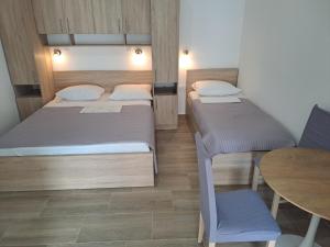 a small room with two beds and a table at Apartmani Frane in Seline