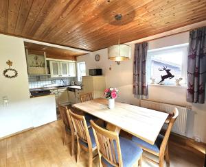 a kitchen and dining room with a wooden table and chairs at Haus Klinsterwald in Sankt Oswald