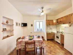 a kitchen with a table with chairs and a white refrigerator at In centro da Isabella in Sperlonga